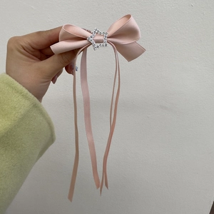 Gros plan sur la barrette à nœud rose avec boucle en strass en forme d'étoile