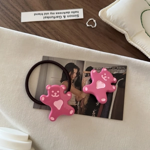 Détail d'un élastique ours rose mignon en résine avec motif de cœur sur tissu blanc