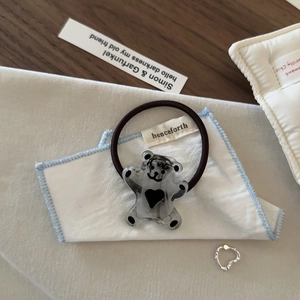 Détail d'élastique à cheveux ours en résine gris transparent avec cœur noir et décor