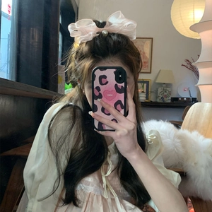 Pink mesh bow hair clip with faux pearl detail shown on a model in a sweet style