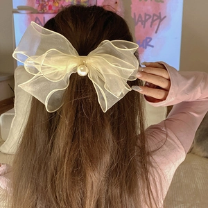 French style cream organza bow hair clip with pearl detail shown on back of head