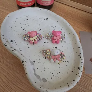 Exquise beertje haarspeldjes met strass steentjes in roze en wit op keramisch dienblad