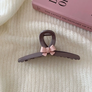 Detailansicht einer dunkelgrauen Haarklammer mit einer zarten rosa 3D-Schleifen-Deko