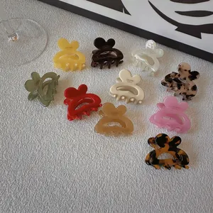 Chic heart-shaped acetate hair claw clips in various colors displayed on white texture