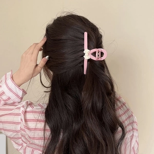 Rosa Haarklammer mit Schleife aus mattem Harz für Damen mit langem braunem Haar