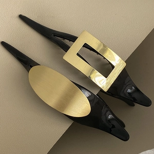 Minimalistische schwarze Haarspangen mit gebürsteter goldener Metalloberfläche