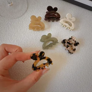 Close-up of tortoise shell and cream butterfly hair clips with polished acetate finish
