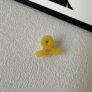 Top view of mini yellow acetate hair claw clip with SUNSHINE Handmade engraving