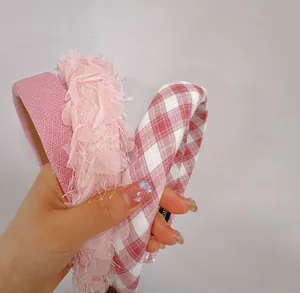 Détail du serre-tête large rembourré avec dentelle rose et tissu à carreaux rouge et blanc