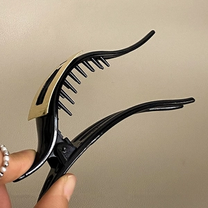 Große matte Haarklammer in Schwarz mit goldenem Metallakzent für elegante Frisuren