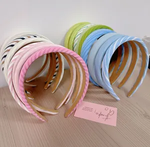 Macro shot of stylish fabric headbands in pastel macaron colors on a wood surface