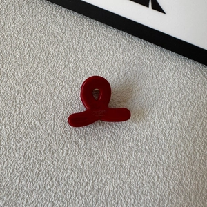 Detail of dark red acetate mini hair claw clip featuring SAMSHINE handmade lettering