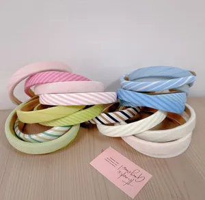 Close-up of colorful thickened sponge headbands in solid and striped patterns on a desk