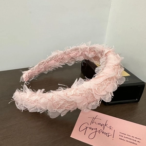 Détail d'un serre-tête rose épais en tulle avec des couches texturées effet pétales doux
