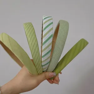 Set of five elegant green fabric headbands for women in various textures and stripes
