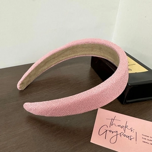 Détail d'un serre-tête rose en tweed rembourré avec tissu texturé et doublure antidérapante