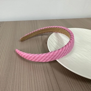 Detail of pink striped padded headband on a ceramic tray with a soft fabric texture