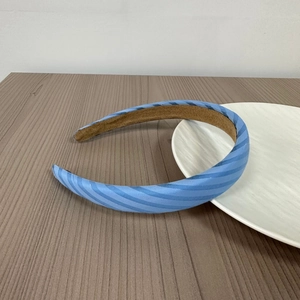 Detail of blue striped headband fabric and anti-slip brown inner lining on wood table