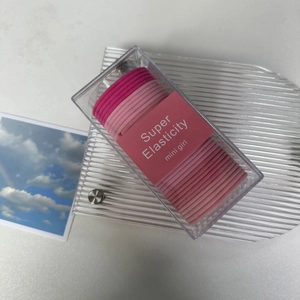 Detail of pink high elasticity hair ties set stored in a clear rectangular plastic box