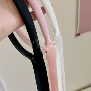 Vue détaillée des serre-têtes en satin avec rubans en noir, rose et blanc crème