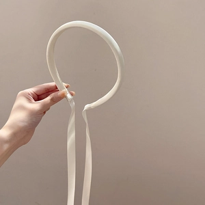 Vue détaillée d'un serre-tête blanc avec de longs rubans en satin pour un style minimaliste