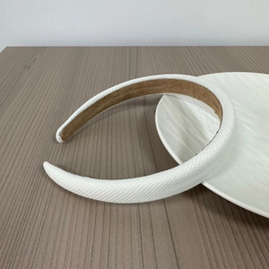 Detailed close-up of textured white woven fabric headband with non-slip suede lining
