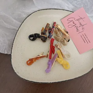 Elegant acetate bow hair clips and duckbill slides in assorted colors on ceramic plate