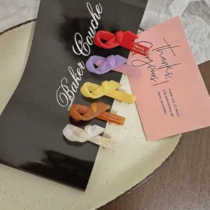 Handmade acetate bow hair clips in vibrant colors including red, purple, and yellow
