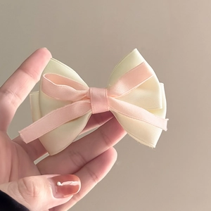 Gros plan détaillé sur un nœud papillon en satin rose et beige double couche à la main