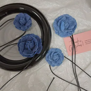 Détail du collier choker fleur de camélia en denim avec de longs rubans noirs à nouer