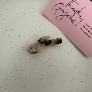 Detail of handmade acetate hair clip with classic leopard print and engraved text