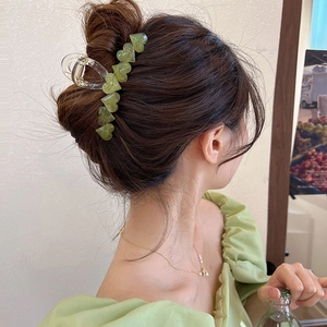 Molla per capelli a cuore verde Morandi effetto jelly indossata su uno chignon bruno