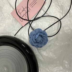 Détail du collier choker camélia en denim fait main avec pétales effilochés élégants