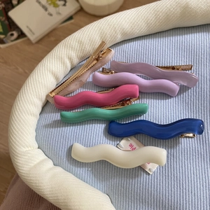 Colorful wave-shaped acrylic hair clips in six vibrant candy colors with gold metal base