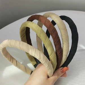 Serre-têtes artisanaux en tissu aux tons terreux avec textures plissées verticales