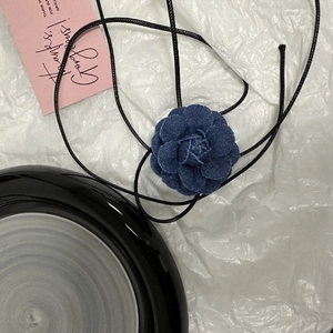 Vue détaillée du collier camélia en denim bleu fait main avec long cordon noir à nouer