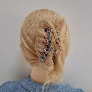 Large tortoiseshell acetate shark hair claw clip worn on blonde wavy hair
