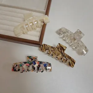 Elegant large acetate shark hair clips in cream white, amber tiger, and marble patterns