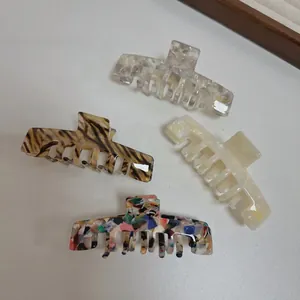 Detailed set of four large acetate hair claws with marble and tortoiseshell patterns