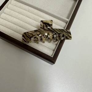 Detailed macro view of large acetate hair claw clip with brown tortoiseshell pattern
