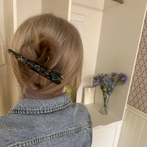 Close-up of elegant marble pattern hair clip on a low bun hairstyle for women