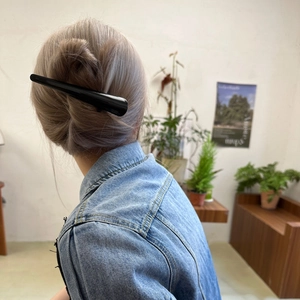 Detail view of a premium black acetate hair clip styled in an elegant updo