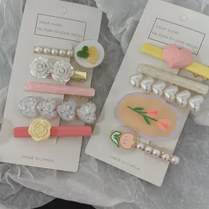 Detail of five-piece hair clip set featuring pearl hearts and cream tulip designs