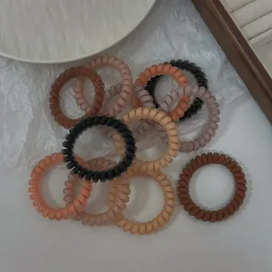 Détails macro des élastiques à cheveux en spirale mate aux tons de terre variés