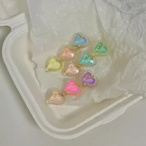 Colorful heart hair clips with golden metal edges on white decorative paper packaging