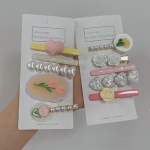 Detail view of handmade cream floral hair clips with pearls and tulips on cards