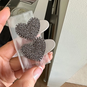 Detailed macro view of heart-shaped hair clips with grey rhinestones in a pack of two