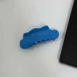 Detail view of large bright blue cloud-shaped acetate hair claw clip with glossy finish