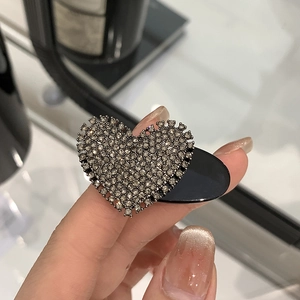 Macro shot of heart hair clip with dark grey rhinestones and serrated edges