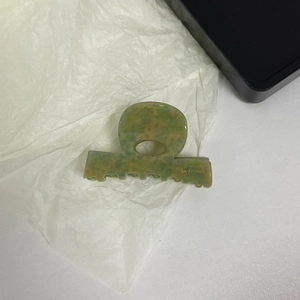 Close-up of marble pattern acetate hair claw clip with Barrette la France lettering